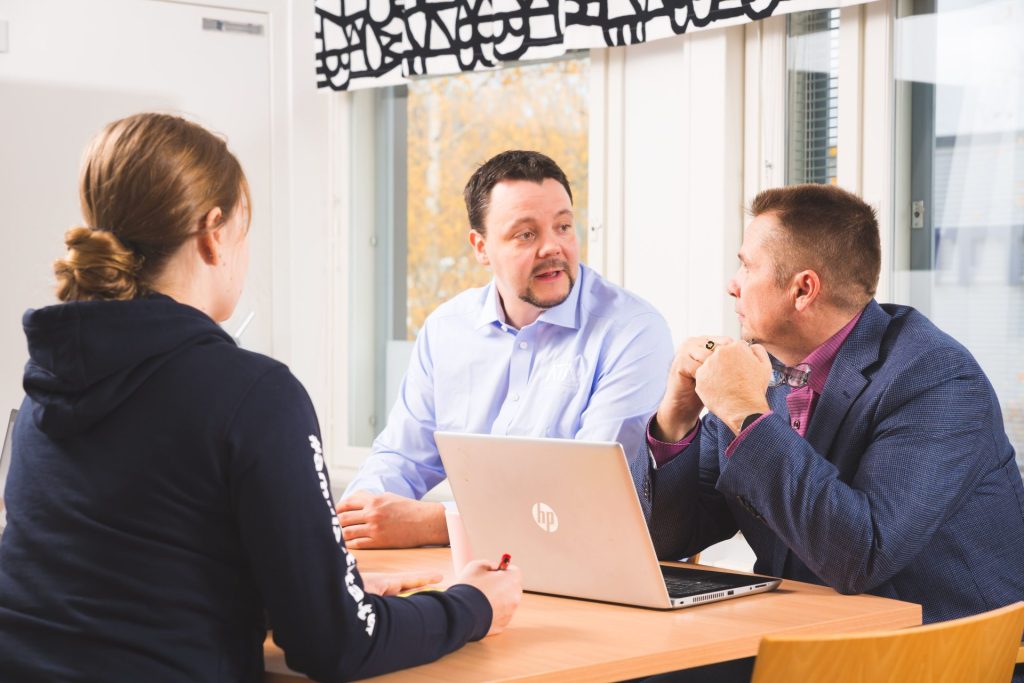 ATA:n toimistolla pöydän ääressä Janne-Pekka Pesonen, Harri Apell ja Aretta Rundgren.