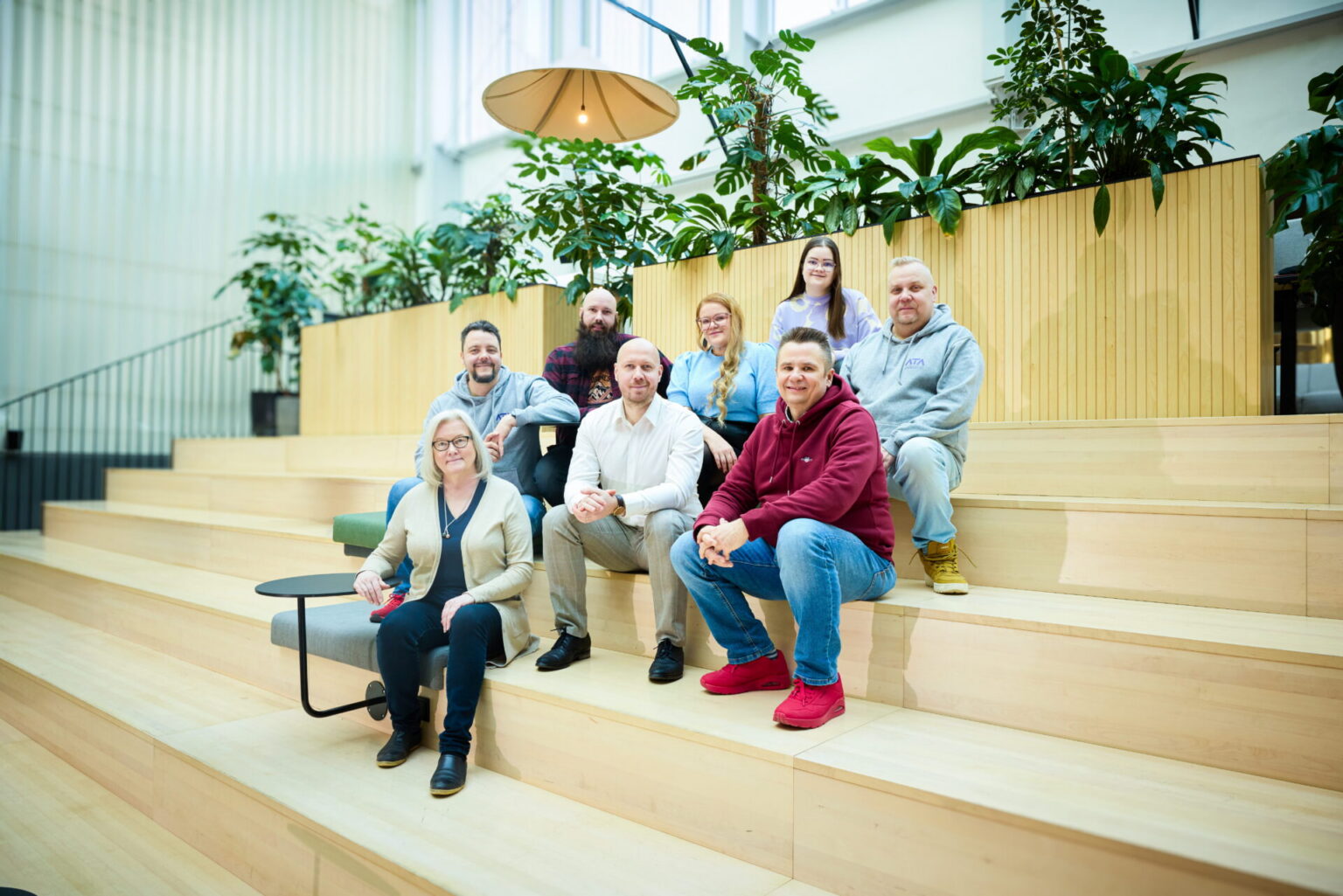 ATAn kahdeksan toimihenkilöä istuvat portailla ja katsovat kameraan