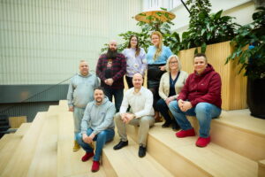 ATAn tiimi poseeraa kameralle portaikossa